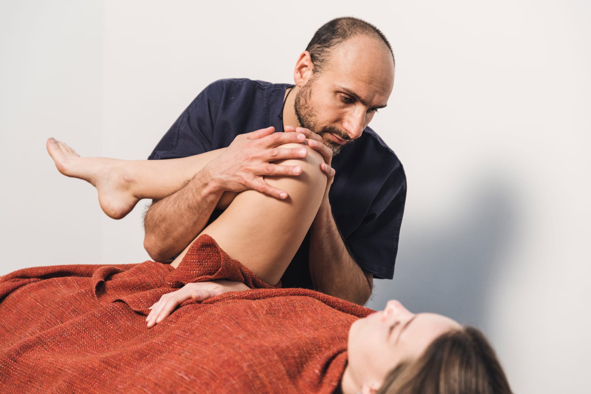 Operatore olistico applica trattamento sulla gamba di una donna